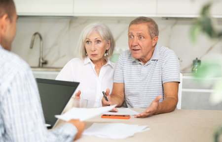 Elderly couple discussing deal with male salesman