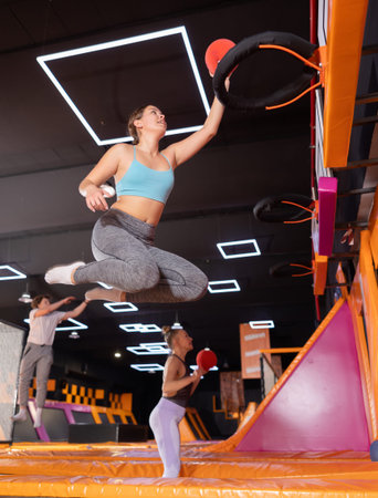 Young woman playing ball in trampoline center