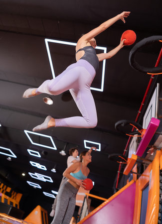 Adult woman playing ball in trampoline center