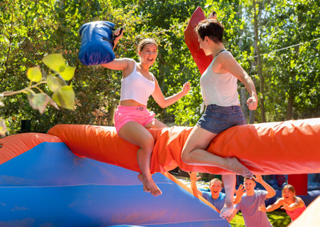Playful women fighting with pillows in amusement park
