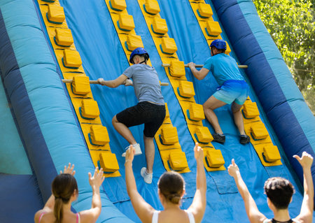 Men climbing up on slide in adventure park