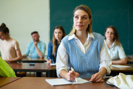 Female student writing during lecture in class room