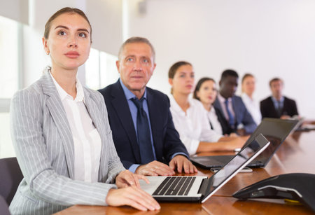 Woman secretary using laptop during conference