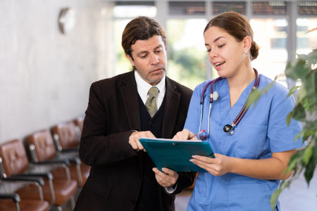 Adult man in suit and young woman doctor with folder of documents