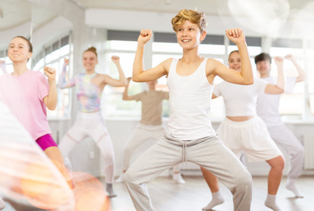 Group of teenagers learn to dance hip-hop and other modern dances in spacious dance studio