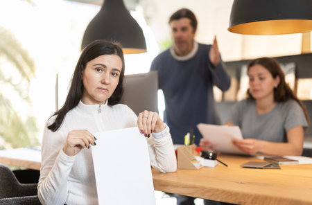 Upset woman reads contract. Managers try to prove their case