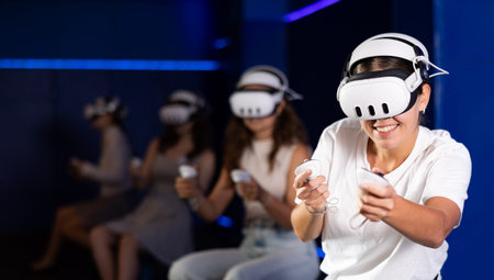 Girls wearing VR headsets and playing games.
