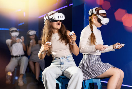 Female friends playing pair versus pair virtual reality game