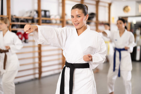 Women students repeat position and perform sequence of punches and techniques kataの写真素材