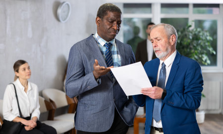 African man talking to elderly man in the hallway