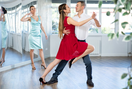 Couple in stage costumes learns tango dancing during individual lessonの写真素材
