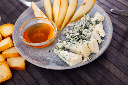 Pieces of blue cheese served on wooden table