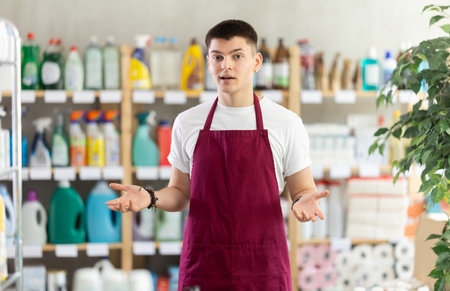 Young man seller in household chemicals storeの写真素材