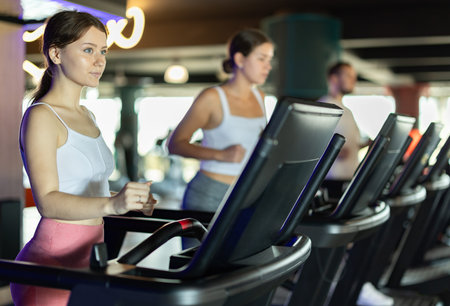 Young woman exercising on treadmill in gym