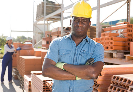 Portrait of a concentrated african american man worker standing in a warehouseの写真素材