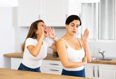 Woman ignoring another woman standing in background and arguing with her