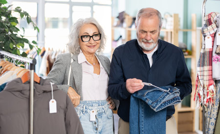 Mature man and woman choosing jeans in the store