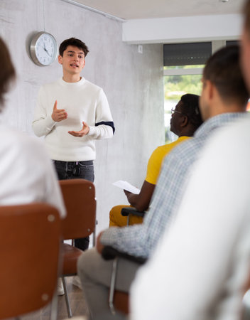 Young student presenting report to group of male students