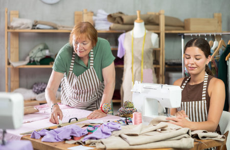 Young woman sewing, elderly woman drawing on fabricの写真素材