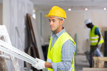 Builder carrying construction detail while working in apartment