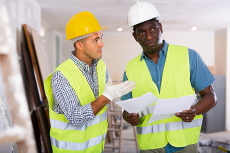 Man and man builders discussing project documentation