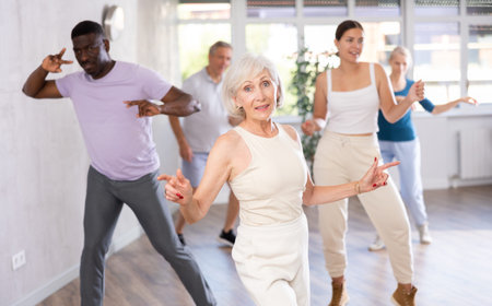 Men and women of different ages practicing Rock n Roll dance in training hall