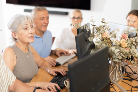 Computer literacy lessons in nursing home for elderly. Mature woman at computer