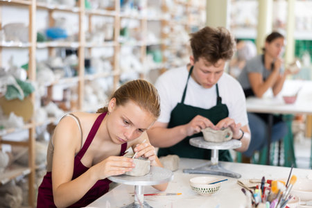 Teenagers are interested in making dishes from clay in pottery workshop
