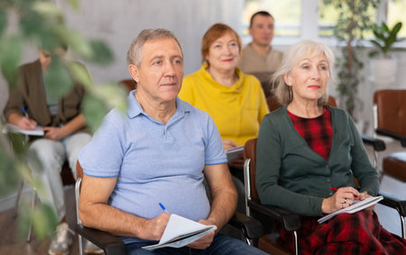 Interested elderly man listening lesson during language coursesの写真素材