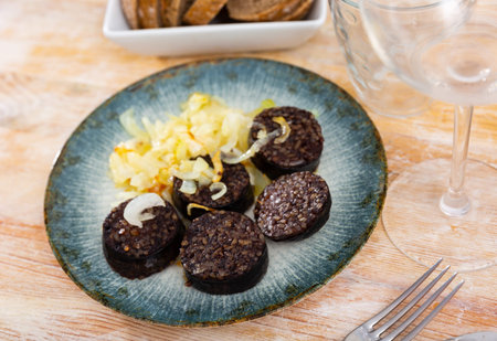 Slices of fried morcilla served with caramelized onions