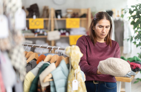 Adult woman choosing hat in clothing store
