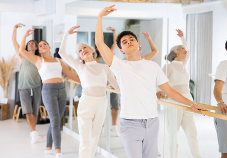 Diligent young man doing choreography at ballet barre