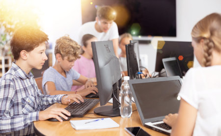 Boy student learning to work on computer in classroom