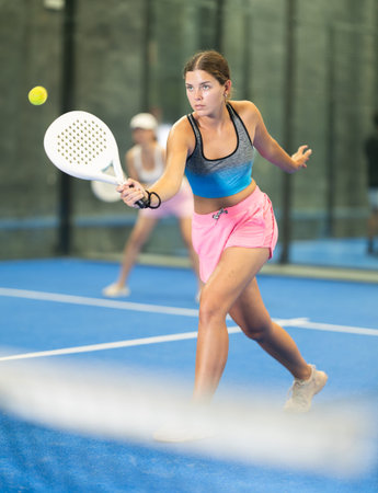 Young and adult women playing doubles tennis