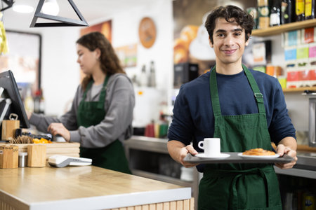 Barista guy presenting coffee and croissant, give out order