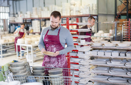 Pottery expert inspecting handmade plate in artisanal ceramics studio