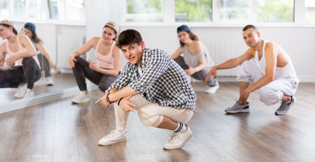 Group of young friends learn group dances - hip-hop and breakdance in dance studio