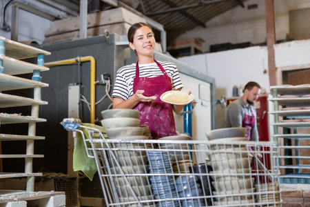 Young woman posing with ceramic dishes
