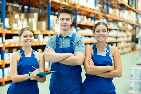 Young female and male employees of store goods for repair and construction are standing in warehouse