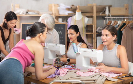 Group of women sewing, drawing and communicating at dressmaking courses