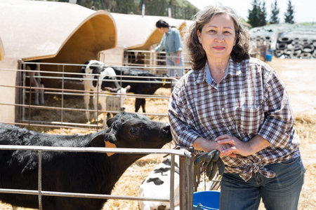 Mature female farmer posing at the cow farm