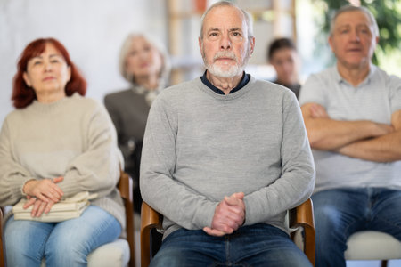 Elderly man listening and watching presentation