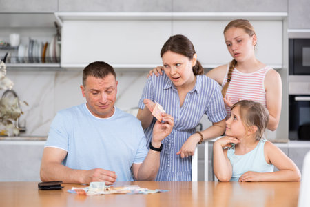 Spouses discuss unpleasant financial issue in kitchen, irritated wife takes money from husband