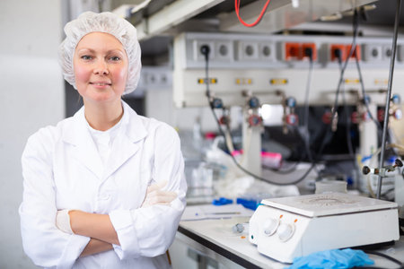 Portrait of a positive female laboratory assistant in uniform in biochemical laboratory