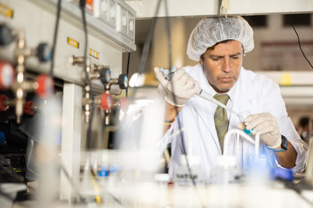 Biochemist performing experiments in lab room, mixing and analyzing chemical agents