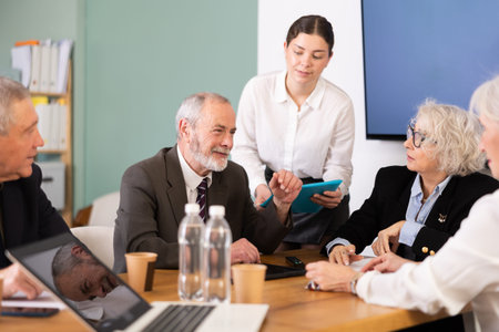 Female secretary gives folder with documents to elderly man