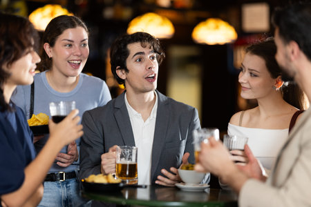 Group of friends happily having time at bar