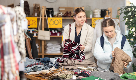 Woman with daughter choosing a sweater near the counter