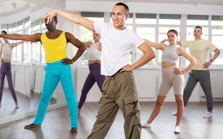European guy with team of like-minded multinational people learn to elements of waacking dance