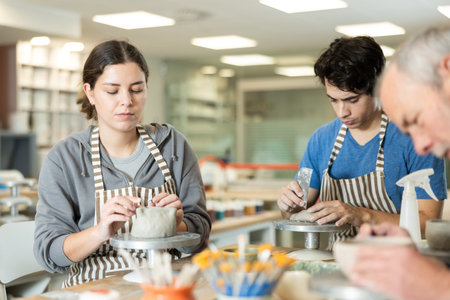 Young woman and man and elderly man crafting ceramics